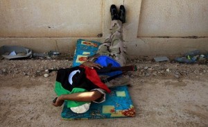 A Libyan rebel fighter covered by the rebel flag