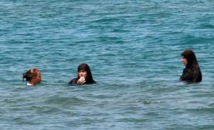 Albanian women wearing conservative Islamic attire swim in the sea in Spille
