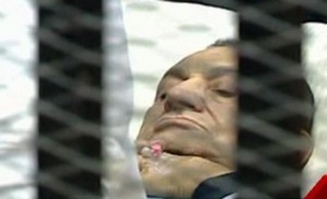 Hosni Mubarak lies on a bed during his trial