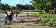 A motorcyclist drive past barricades of the Islamic sect Boko Haram in Maiduguri, …