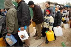 Gaza Arabs wait to fill containers with fuel at a gas station