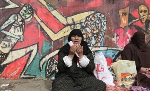 A woman prays in Tahrir Square
