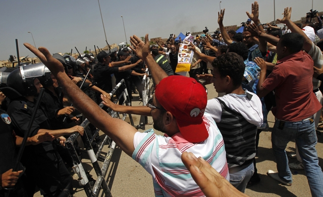 Egyptian riot policemen - protesters shout against Hosni Mubarak outside a court in Cairo. AFP