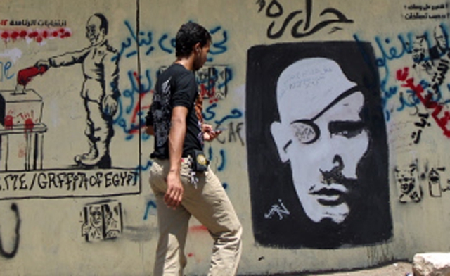 Grafitti show head of the Egyptian ruling military council Field Marshal Hussein Tantawi left using a bloody hand to vote in Cairo AFP