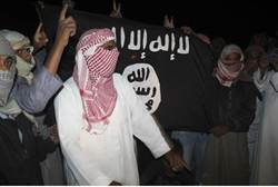 protesters carry an al Qaeda flag - Reuters