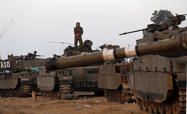 An Israeli soldier stands atop a tank at a staging area near the border with central Gaza November 20 2012. Reuters
