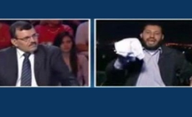 Salafi cleric and imam brandishing a white cloth used for a coffin as a sign to sacrifice his life. Al Arabiya