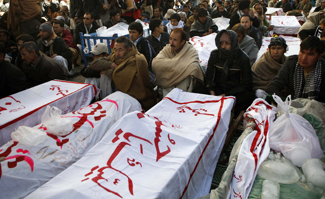 Shiite Muslims display the unburied coffins of victims