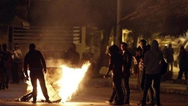 protesters attempt to close a road during clashes with riot police in Cairo. Reuters