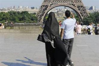 A woman wearing a niqab walks at Trocadero square near the Eiffel Tower in Paris