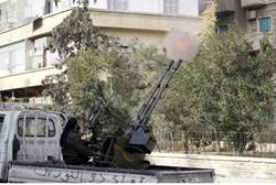 A fighter from the Al Qaeda-aligned Nusra Front fires a mounted machine gun - Reuters