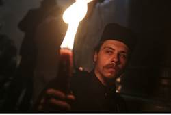 Orthodox Christian pilgrim holds a candle during Easter eve celebrations