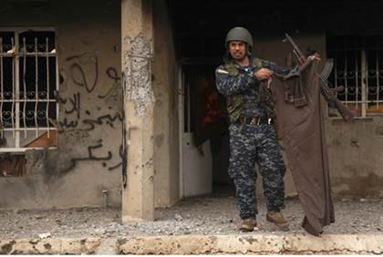 Kurdish Peshmerga fighter displays clothing taken from slain ISIS fighter - Reuters