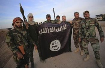 Iraqi Shiite fighters pose with captured ISIS flagReuters